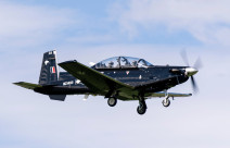 A Royal New Zealand Air Force T-6C Texan II aircraft flying with two people in the aircraft