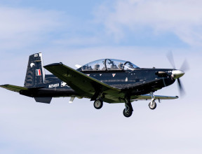 A Royal New Zealand Air Force T-6C Texan II aircraft flying with two people in the aircraft