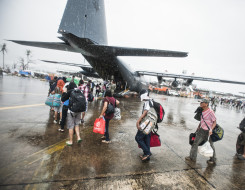 Typhoon Haiyan survivors walk toward the ramp of a RNZAF C-130H(NZ) Hercules in Tacloban, Philippines