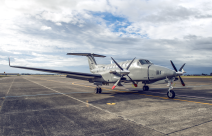 A King Air 350 aircraft sits on the flightline. The sky is cloudy with partial blue sky.