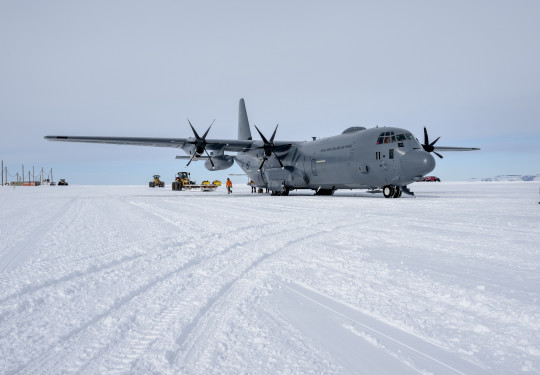 Large grey aircraft parked on the ice in Antarctica