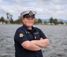 A young man stands with arms crossed while wearing the Navy Cadet uniform.