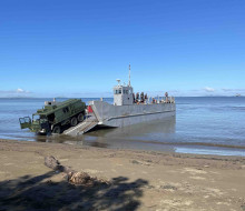 A Pinzgauer vehicle drives off a landing craft on to Lomolomo during Operation Mahi Tah