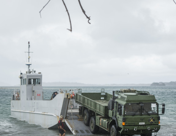 Army personnel and a Medium to Heavy Operation Vehicle are unloaded off an Landing Craft Mechanism from HMNZS Canterbury in Fiji.