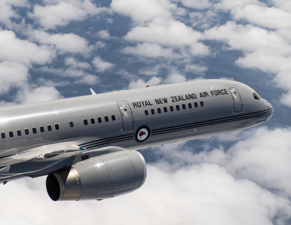 A close up of a Boeing aircraft flying through clouds on a nice day. 