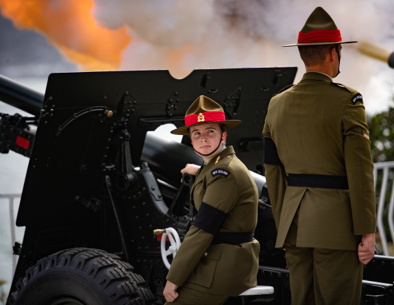 Two Army personnel from 16 Field Regiment next to a light howitzer gun waiting to receive orders to fire