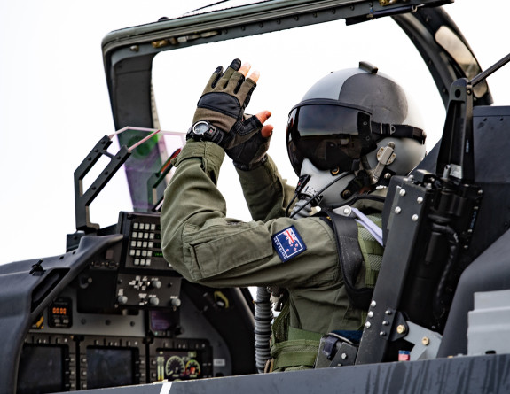 A pilot performs hand signals in the cockpit of a Royal New Zealand Air Force T-6C Texan aircraft 