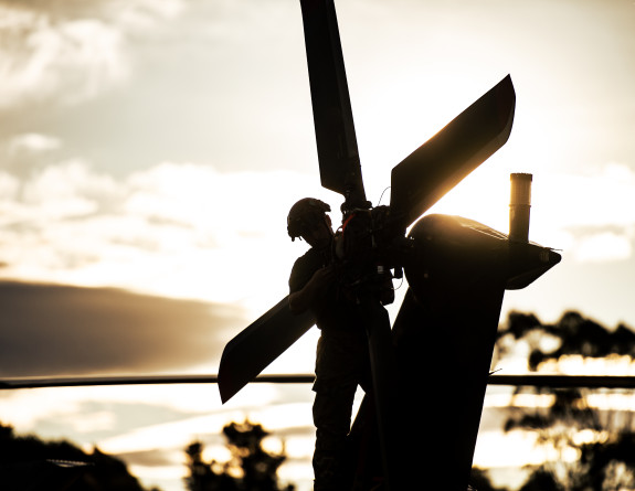 A aircraft technician on an NH90 helicopter - backlit image