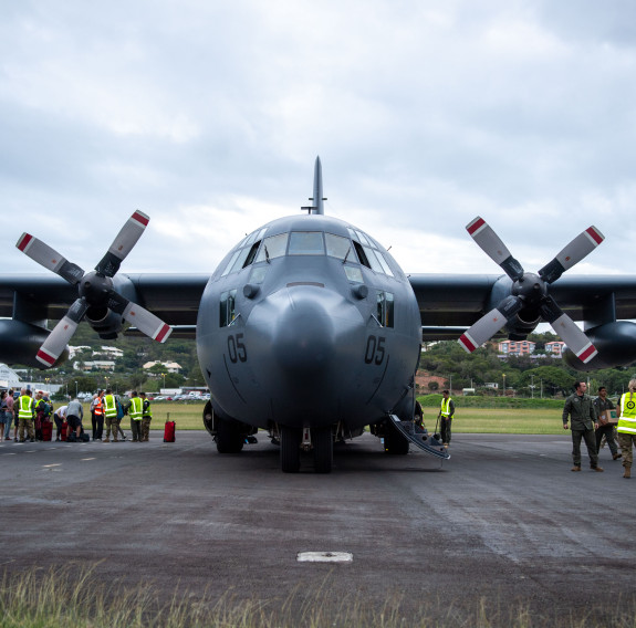 Nose-on view of the Hercules as personnel work to board people from the tarmac.