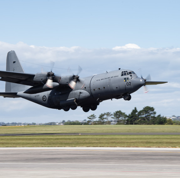 An RNZAF c-130H Hercules taking off. The undercarriage is still down.