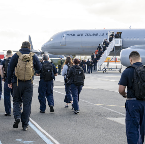 People walk along the tarmac to board a RNZAF Boeing 757-2K2.